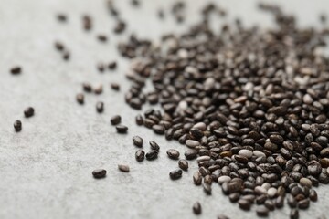 Pile of chia seeds on light grey table, closeup. Space for text