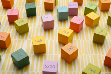 Colorful cubes with numbers and multiplications on yellow background