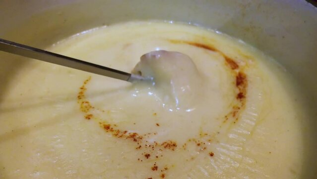 Dipping homemade bread into the classic Swiss Cheese fondue