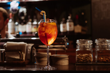 cocktail with ice and a slice of orange in a glass on bar in a restaurant