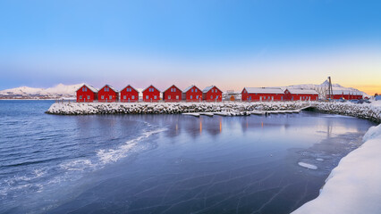 Gorgeous scenery wit traditional red wooden houses on the shore of Offersoystraumen fjord.