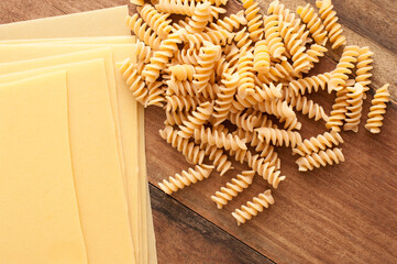 Assorted raw Italian pasta on a wooden table