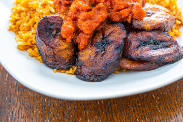 nigerian Jollof Rice served with plantain and stew © primestockphotograpy