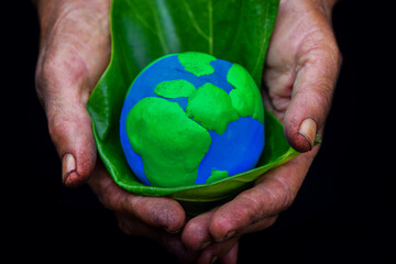 Earth and plant were held in human hands. Earth day. Energy saving concept, ecology, and environment sustainable concept. Saving the environment, saving a clean planet, and net zero. ESG and co2.