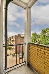 a balcony with a brick wall and blue sky in the background photo is taken from inside an apartment...