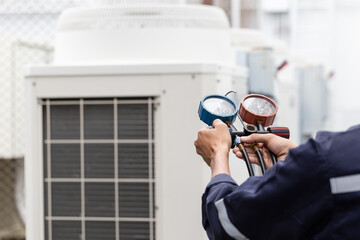 Technician is checking air conditioner ,measuring equipment for filling air conditioners.