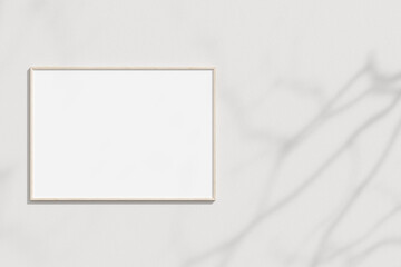 Empty frame on the white wall with branches shadow