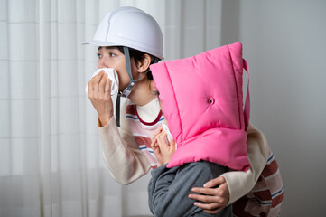 防災頭巾で避難訓練する子どもと先生