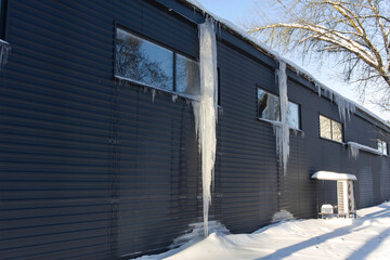 Huge icicles hanging from the roof and threatening significant damage when they fall