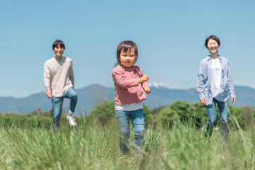 高原・草原・公園を歩くアジア人の親子・家族・ファミリー（女の子）
