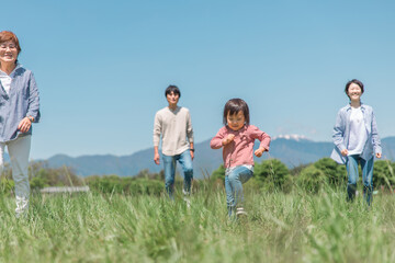 高原・草原・公園を歩くアジア人の三世代家族・親子・ファミリー（女の子）

