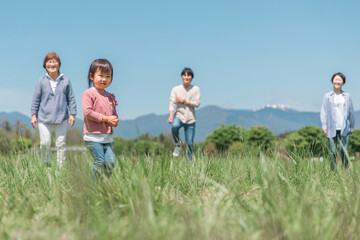 高原・草原・公園を歩くアジア人の三世代家族・親子・ファミリー（女の子）
