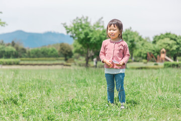 公園でシャボン玉遊びをするアジア人の子供（女の子）
