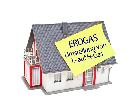Miniature house with the german words for natural gas conversion from L to H Gas - Erdgasumstellung 