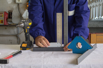 Image of a metalworker in the workshop who finds the precise angle of a mechanical piece to be...
