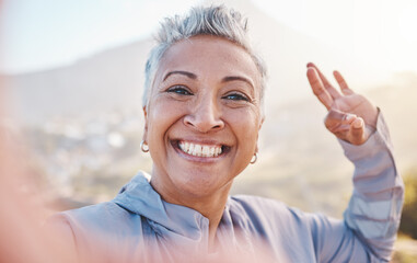 Elderly woman runner, exercise selfie and smile in nature for fitness, wellness or self care with OK hand sign. Happy senior black woman, profile picture and running by mountains, outdoor and workout