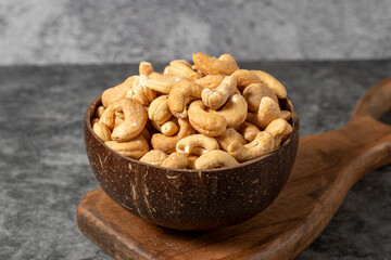 Cashew nuts on dark background. Fresh cashews in coconut bowl. Studio shoot. close up