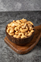 Cashew nuts on dark background. Fresh cashews in coconut bowl. Studio shoot. close up