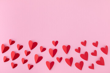 Border of various red hearts on pink background for Saint Valentine day greeting card or banner. .