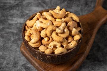 Cashew nuts on dark background. Fresh cashews in coconut bowl. Studio shoot. close up