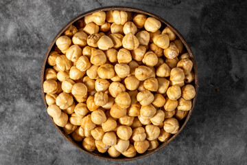 Roasted hazelnut nuts on dark background. Fresh hazelnuts in a coconut bowl. Studio shoot. Top view