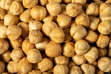 Roasted hazelnut nuts on dark background. Many delicious nuts as background. Studio shoot. Top view