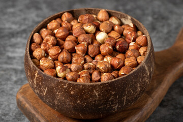 Fresh hazelnut nuts on dark background. Nuts in a coconut bowl. Studio shoot. close up