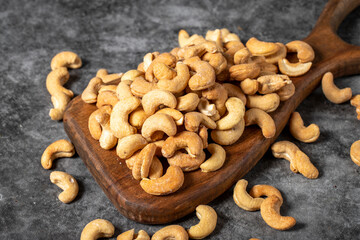 Cashew on wood serving board. A pile of cashews. Studio shoot. close up