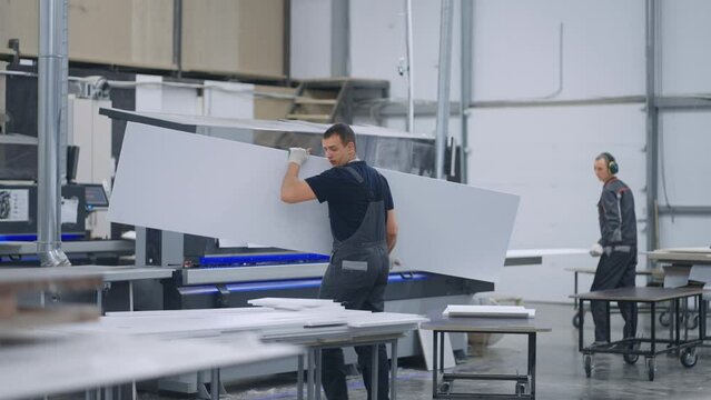 industrial furniture production, men working in workshop, robotic edge banding process