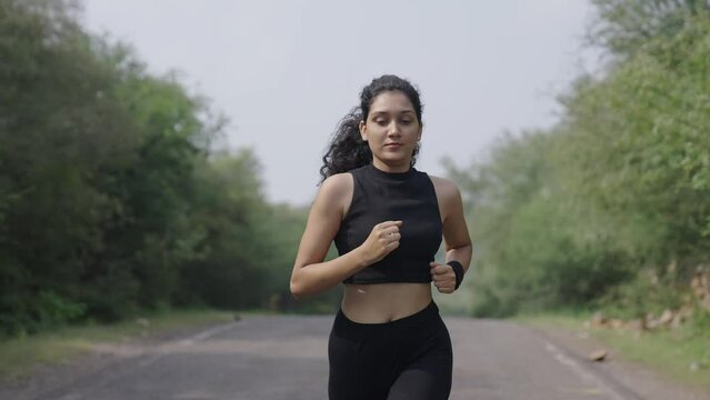 Close up Runner young Asian woman running in the mountain. Close up fitness India female jogging outdoor. Asian girl runner people exercise outdoor. Health care and Lifestyle Concept.