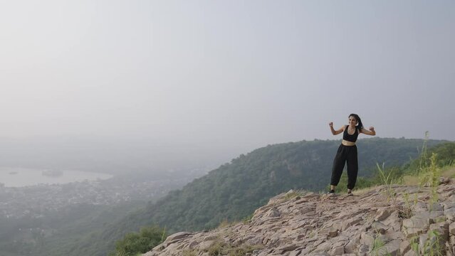 A Indian young  beautiful women on the climb on the mountain on the winner.Asian young girl  in Success Pose morning Hands Up Concept Win and Free.slow motion, Steadicam. 