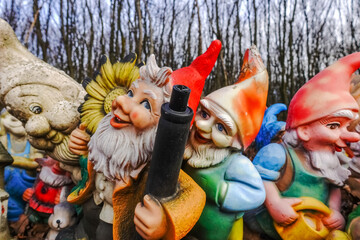 colorful garden gnomes with a gun at a place in the forest