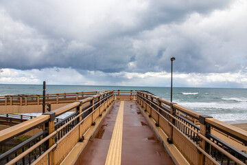 Obraz premium the pedestrian bridge to Hakuto Coast in Tottori Japan. It has a beautiful sandy beach and an impressive view of the ocean stretching to the horizon. A popular date spot for young couples.