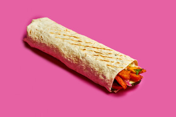 Vegetarian shawarma with sweet potato and sauce on a pink background.