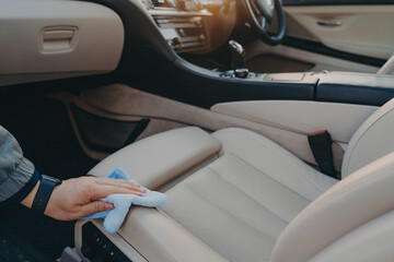 Fototapeta Male hand disinfecting fabric car seat with microfiber cloth obraz