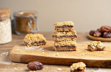 Homemade old fashioned date squares or Matrimonial bars on wooden cutting board with ingredients