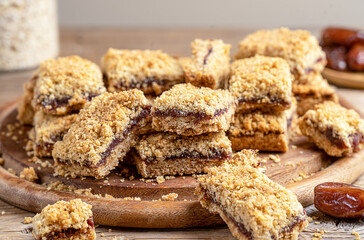 Homemade old fashioned date squares or Matrimonial bars on wooden cutting board with ingredients