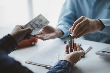 A car rental company employee pointed out the renter to sign the rental agreement after discussing...