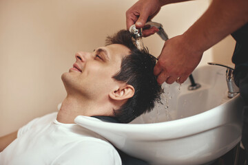 Obraz na płótnie Canvas Barber washing hair of caucasian man , close-up