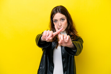 Fototapeta premium Young caucasian woman isolated on yellow background making stop gesture with her hand to stop an act