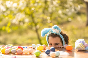 happy teen girl wear bunny ears with Easter eggs in the garden