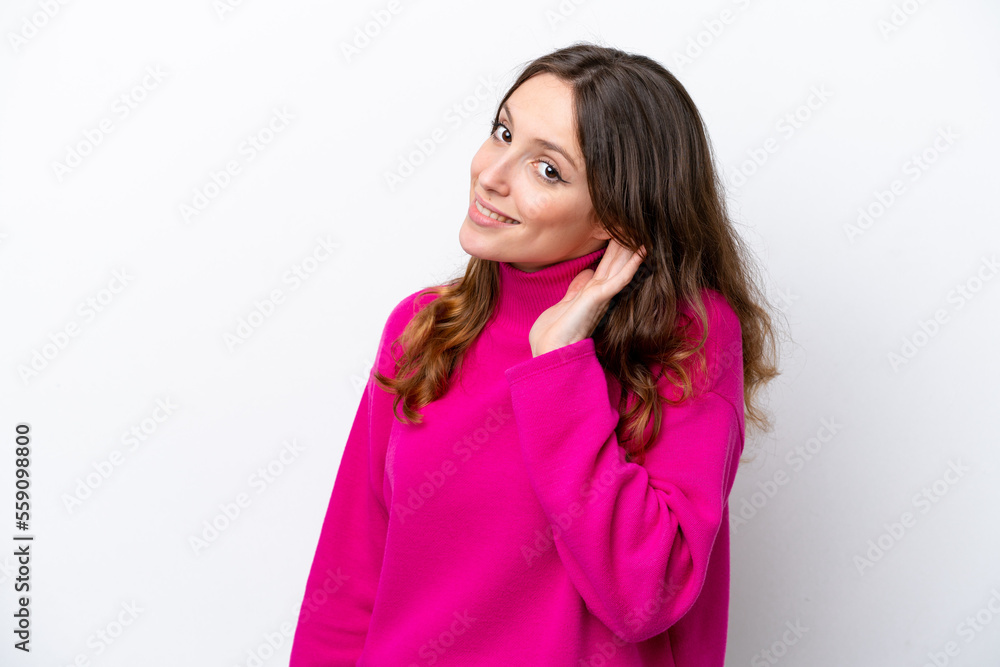 Canvas Prints Young caucasian woman isolated on white background listening to something by putting hand on the ear