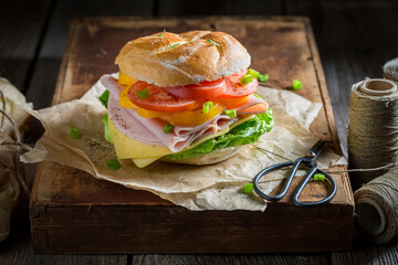 Crispy take away sandwich with ham, tomatoes and cheese.