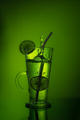 Elegant lemon drink on green color, on a table