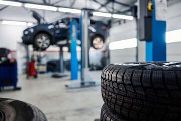 Naklejka na ściany i meble Selective focus on a new tires ready for changing in mechanic's shop.