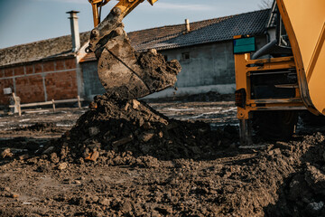 Cropped picture of an excavator digging soil on construction site.
