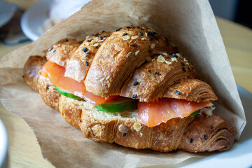 croissant with sesame, salmon and cucumber, on the table, selective focus, close-up