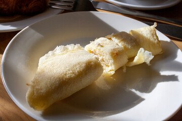 egg roll, in the rays of sunlight, lying on a plate with a shadow, selective focus, close-up