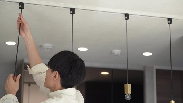 照明器具を取り付ける男性