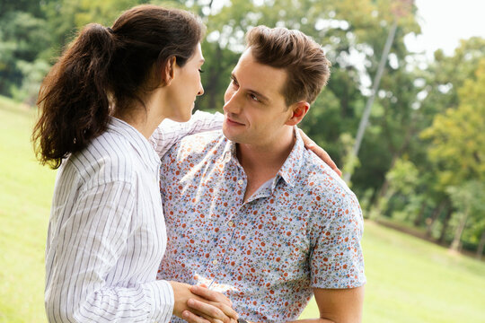 Young Couple Man And Woman Falling In Love And Dating In Park. Wife Hugging And Enjoying With Smiling Of Her Husband  In Romantic Travel Holiday. Happy Family.